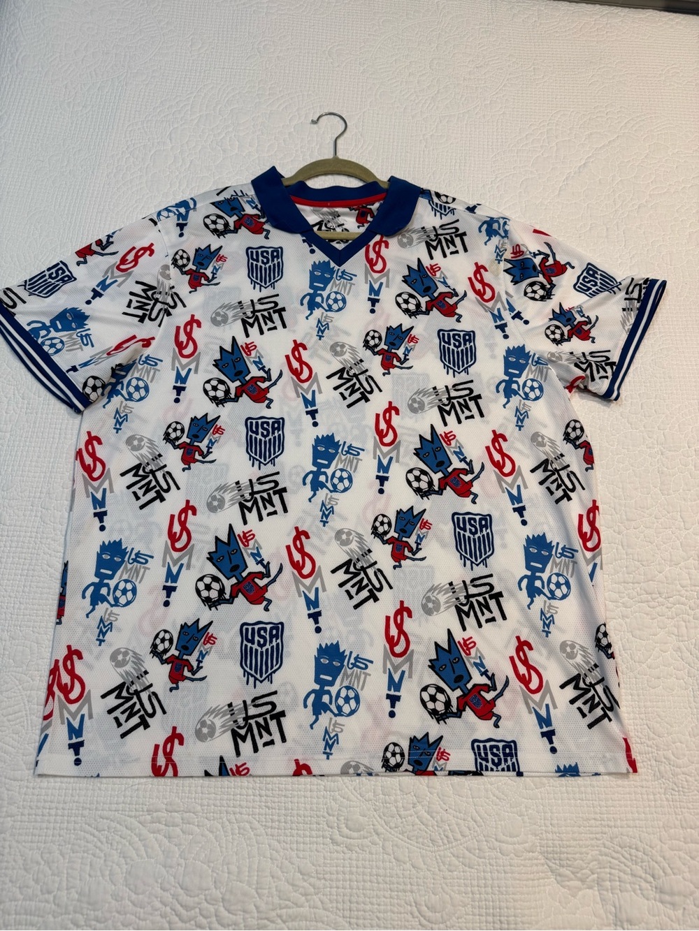 Antigua White Short Sleeve Soccer Graphic Jersey with Red & Blue Accents